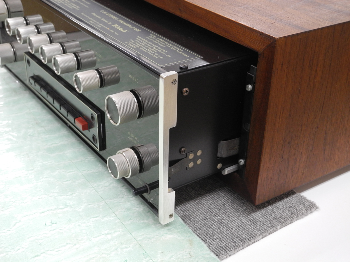 バネを指で押し込んで、アンプをウッドキャビネットの奥へ押し込む例2